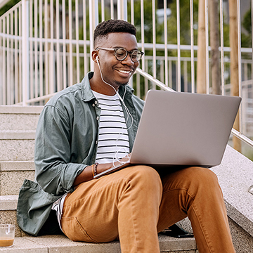 Happy man with headphones working on laptop