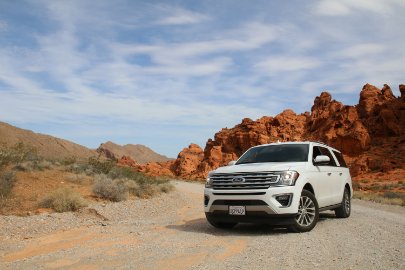 DebitCardCloseup_Promos-2.jpg White jeep on dirt road in desert landscape