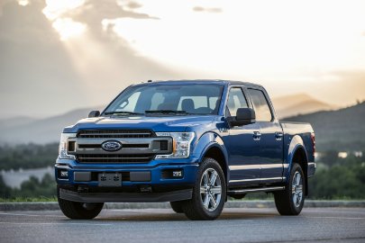DebitCardCloseup_Promos.jpg shiny blue Ford truck with natural landscape in background